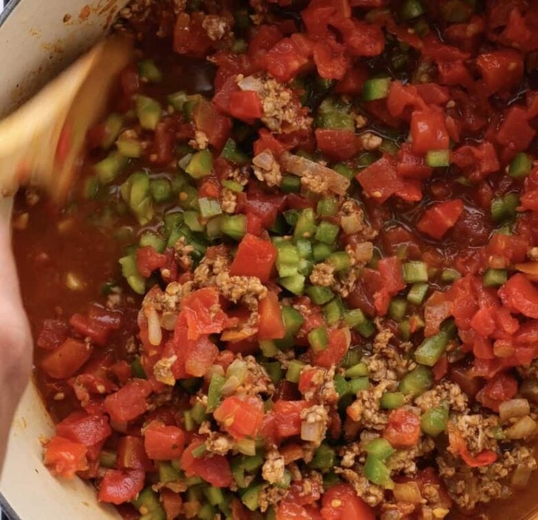 bell peppers and tomatoes added to chili.