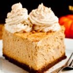 Slice of pumpkin cheesecake with whipped cream topping.
