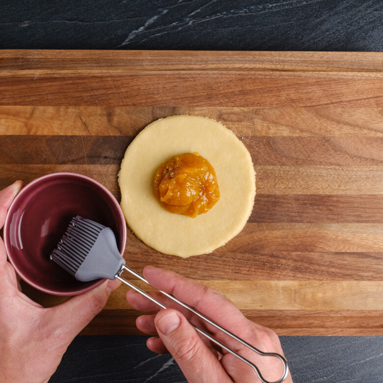 pumpkin pasties filling in dough circle.