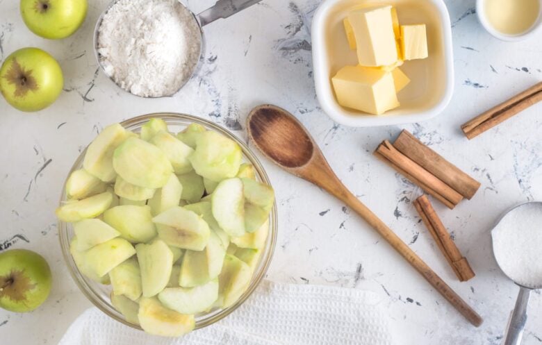 apple pie ingredients including apples, butter, flour, sugar, cinnamon.