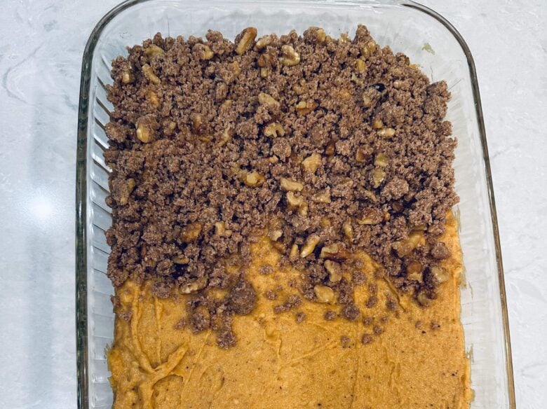pumpkin coffee cake batter and streusel in baking dish.
