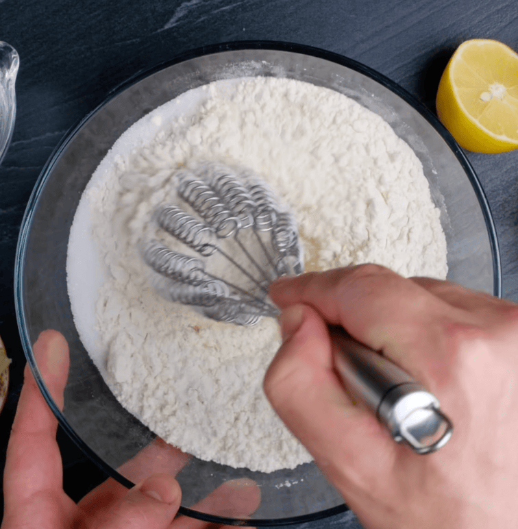 Easy dinner roll dry ingredients being whisked in a large glass bowl.