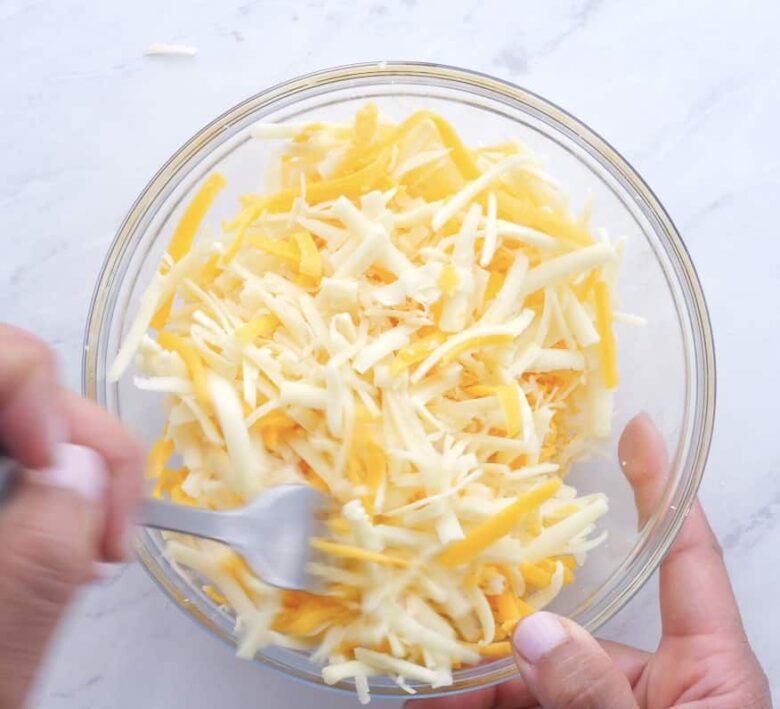 cheesy scalloped potatoes cheeses mixed in a bowl.