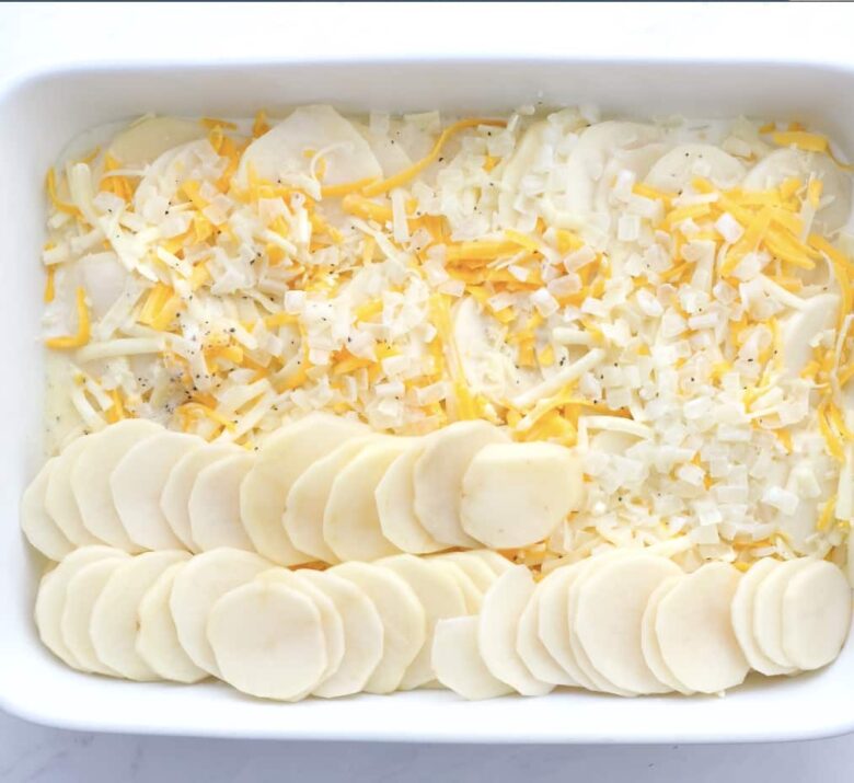 scalloped potatoes layered in baking dish.