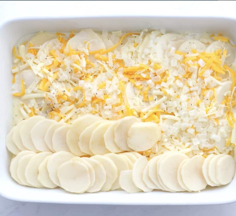 https://www.chewoutloud.com/wp-content/uploads/2023/11/Scalloped-Potatoes-Layered-in-Baking-Dish-780x715.jpg