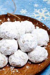 snowball cookies stacked on a plate.