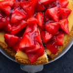 strawberry cheesecake whole with strawberries on top.
