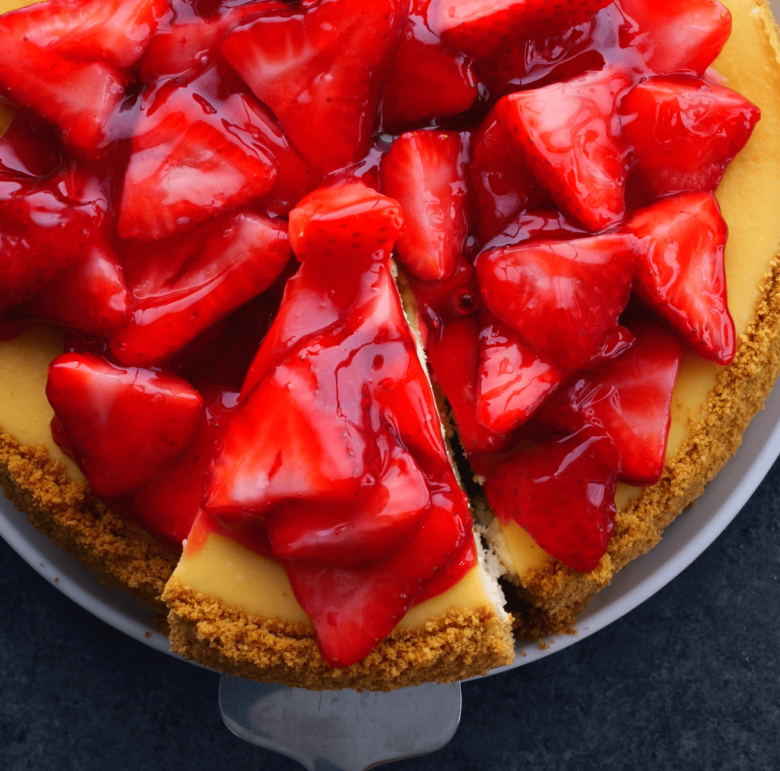 A slice of strawberry cheesecake on a plate.