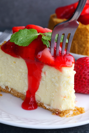 slice of strawberry cheesecake with a fork.