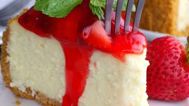 slice of strawberry cheesecake with a fork.