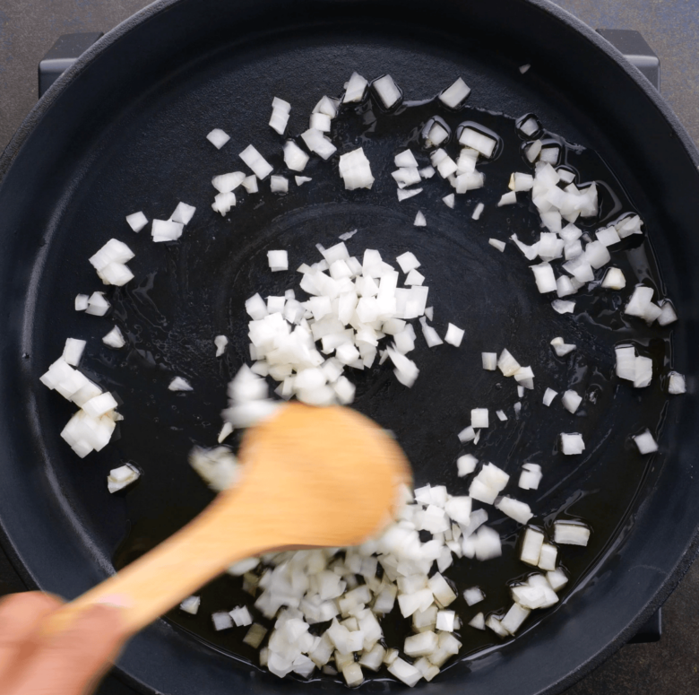 garlic and onions being cooked in a pan.