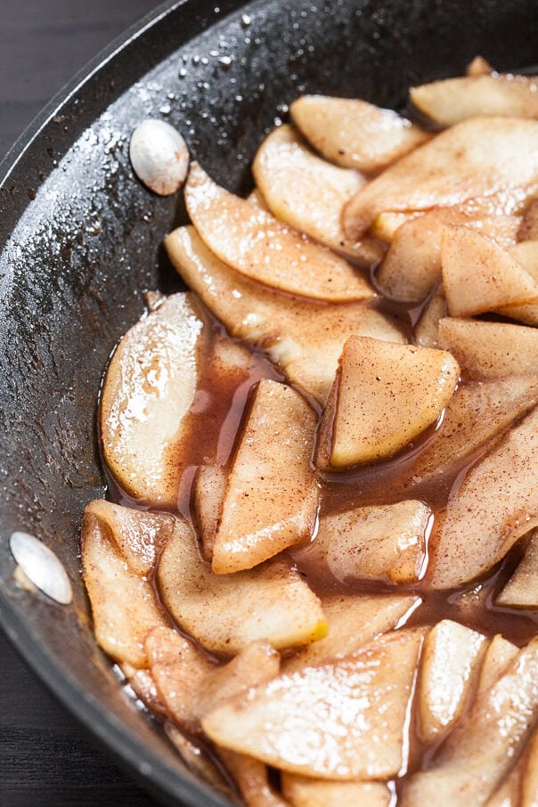 apples being cooked in a pan for apple french toast bake