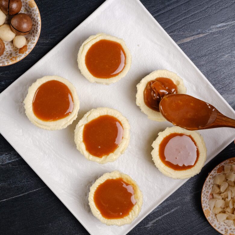 salted caramel being added to cheesecake bites.