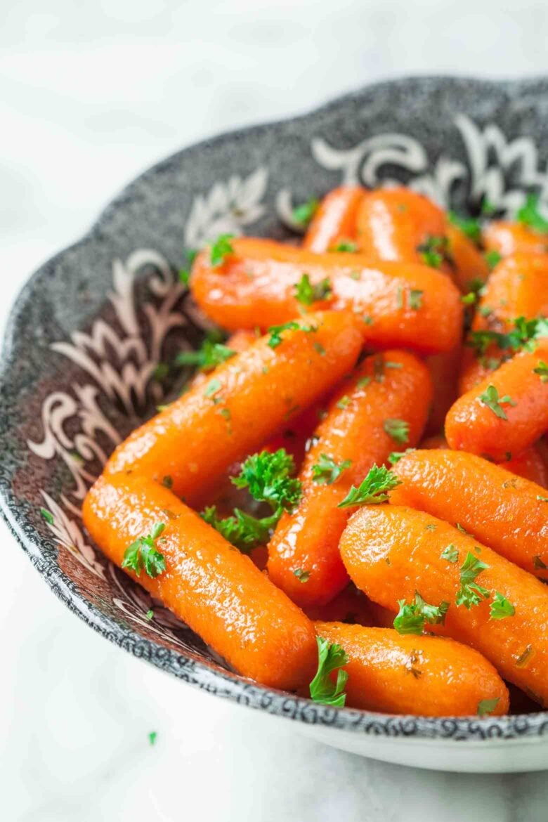 Honey glazed roasted carrots in a bowl with parsley.