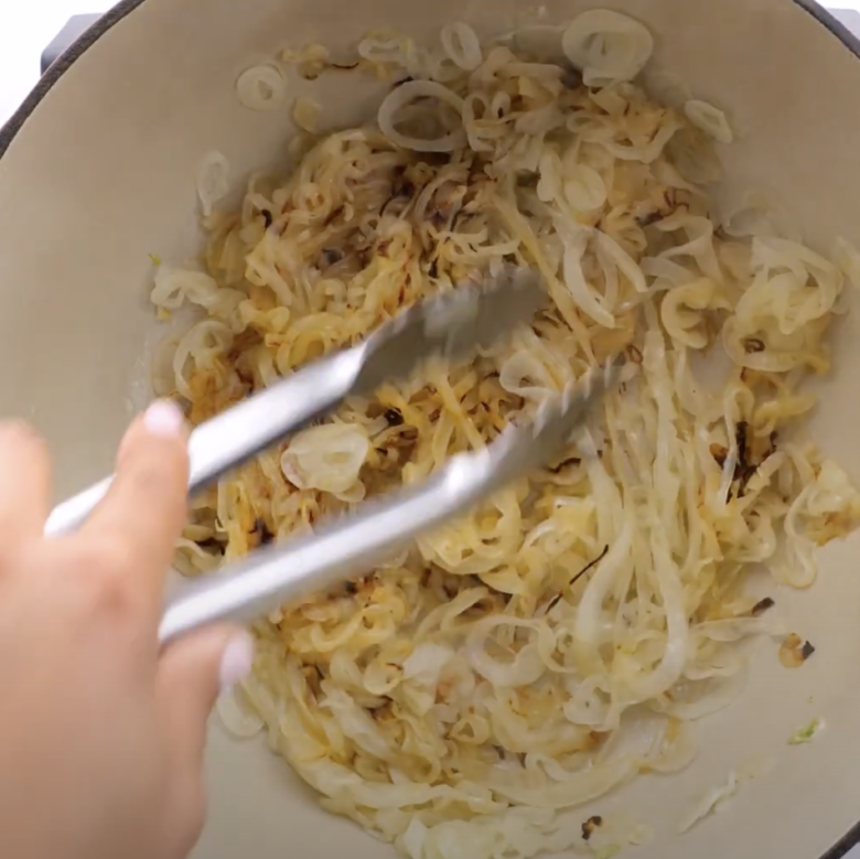 Onions and garlic being sauteed in a Dutch oven.