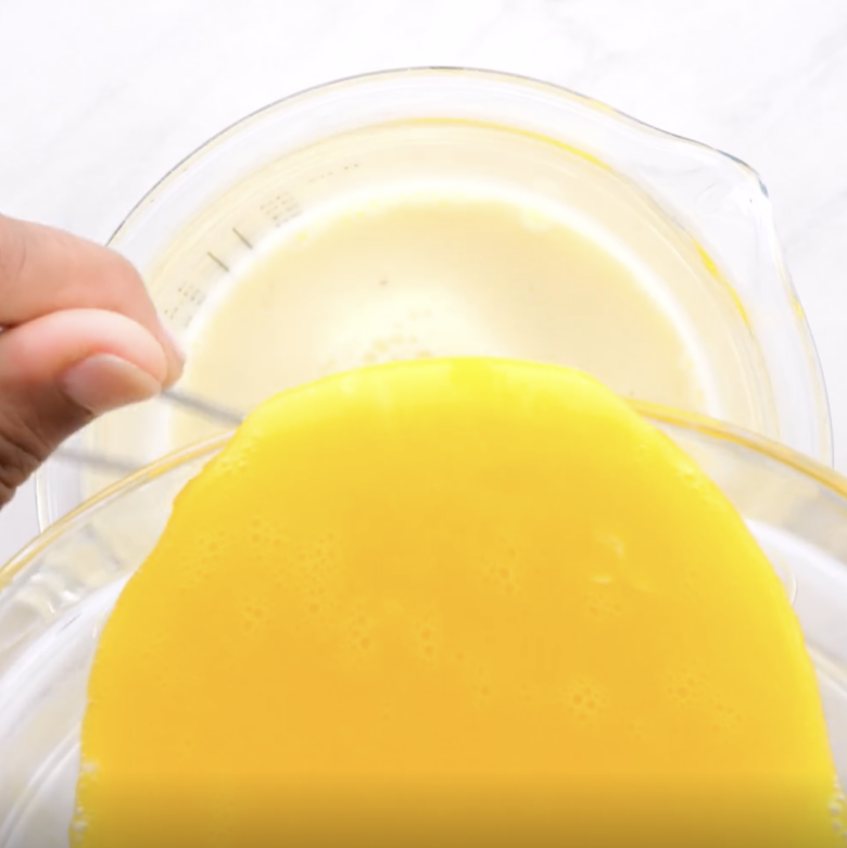 Whisked egg yolks being tempered into creme brulee cream mixture.