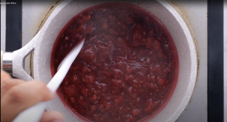 Raspberry sauce being cooked for mini cheesecake bites.