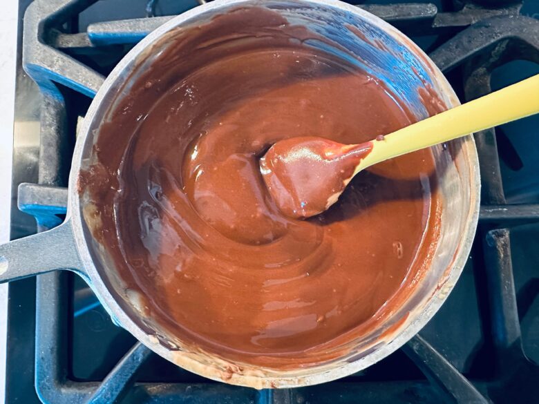 A saucepan with melted chocolate mixture to make puppy chow.