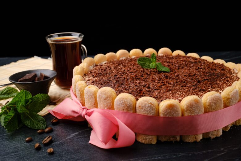 A tiramisu recipe with ladyfingers wrapped in red ribbon.