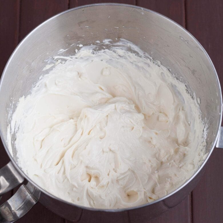 A bowl of a stand mixer with cream cheese frosting.