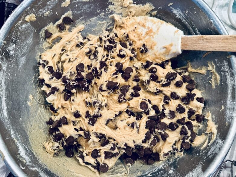 chocolate chips being folded into cookie bar batter.