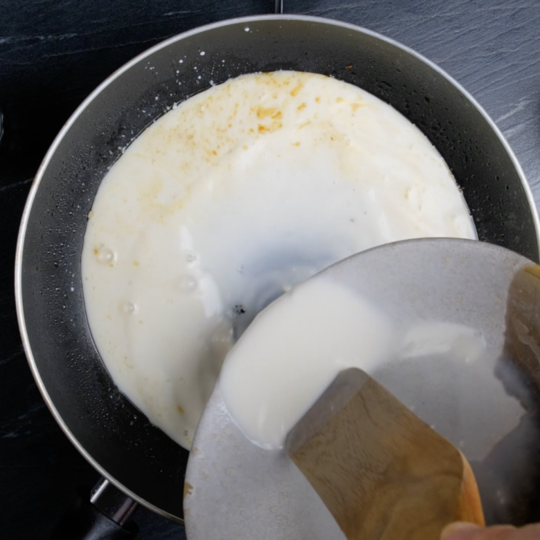 Creamy lemon chicken sauce being cooked in a pan.