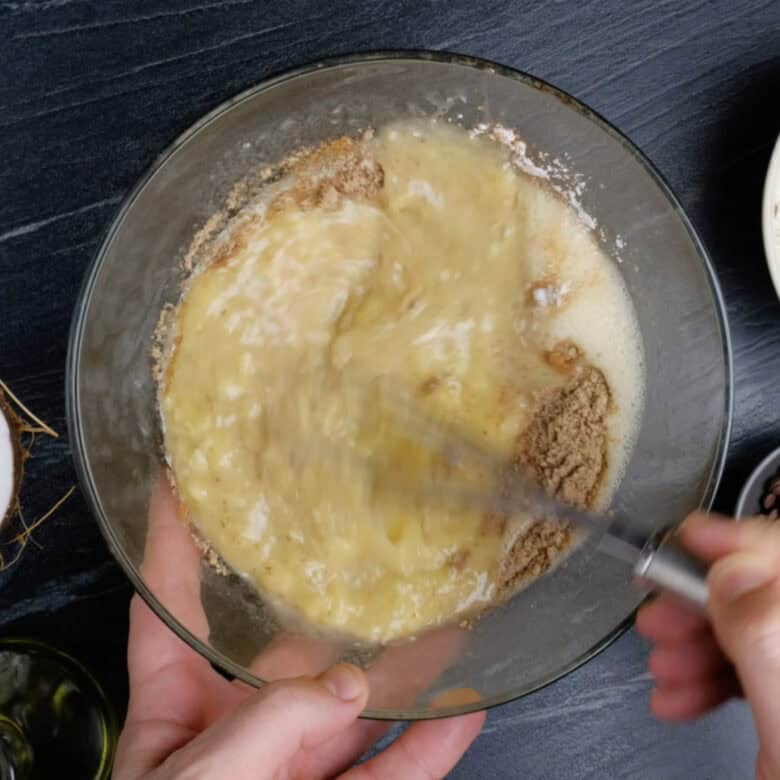 Cinnamon being whisked into dairy-free banana bread batter.