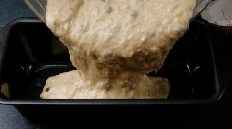 Dairy-free banana bread batter being poured into a pan.