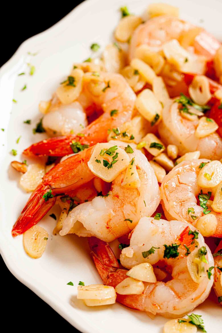 Closeup shot of garlic shrimp with perfectly tender shrimp and sauteed garlic.