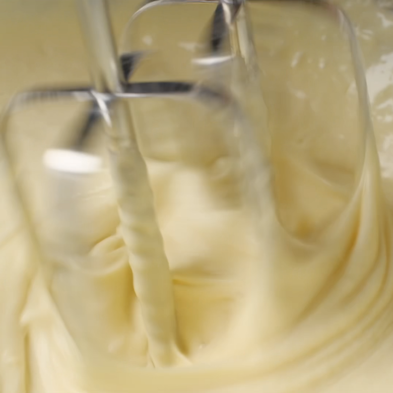 Popovers batter being blended with a hand mixer. 