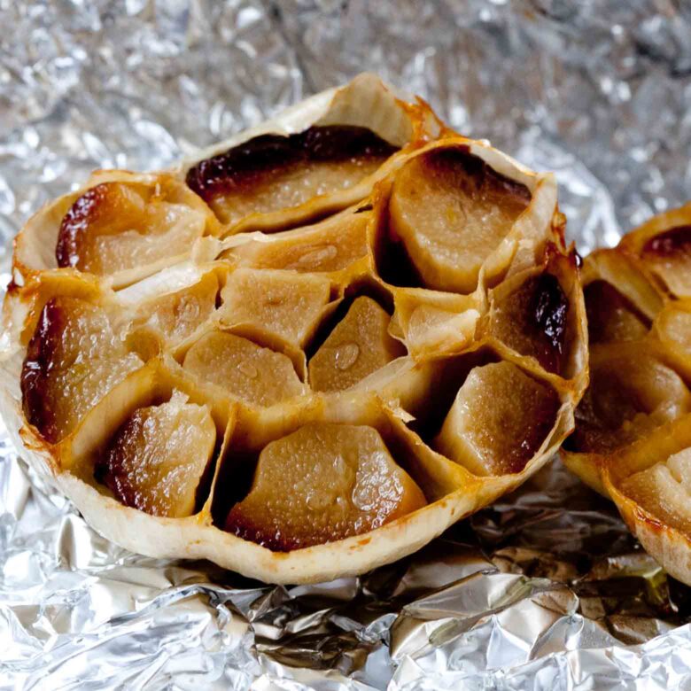 Roasted garlic pod sliced in half on tin foil.