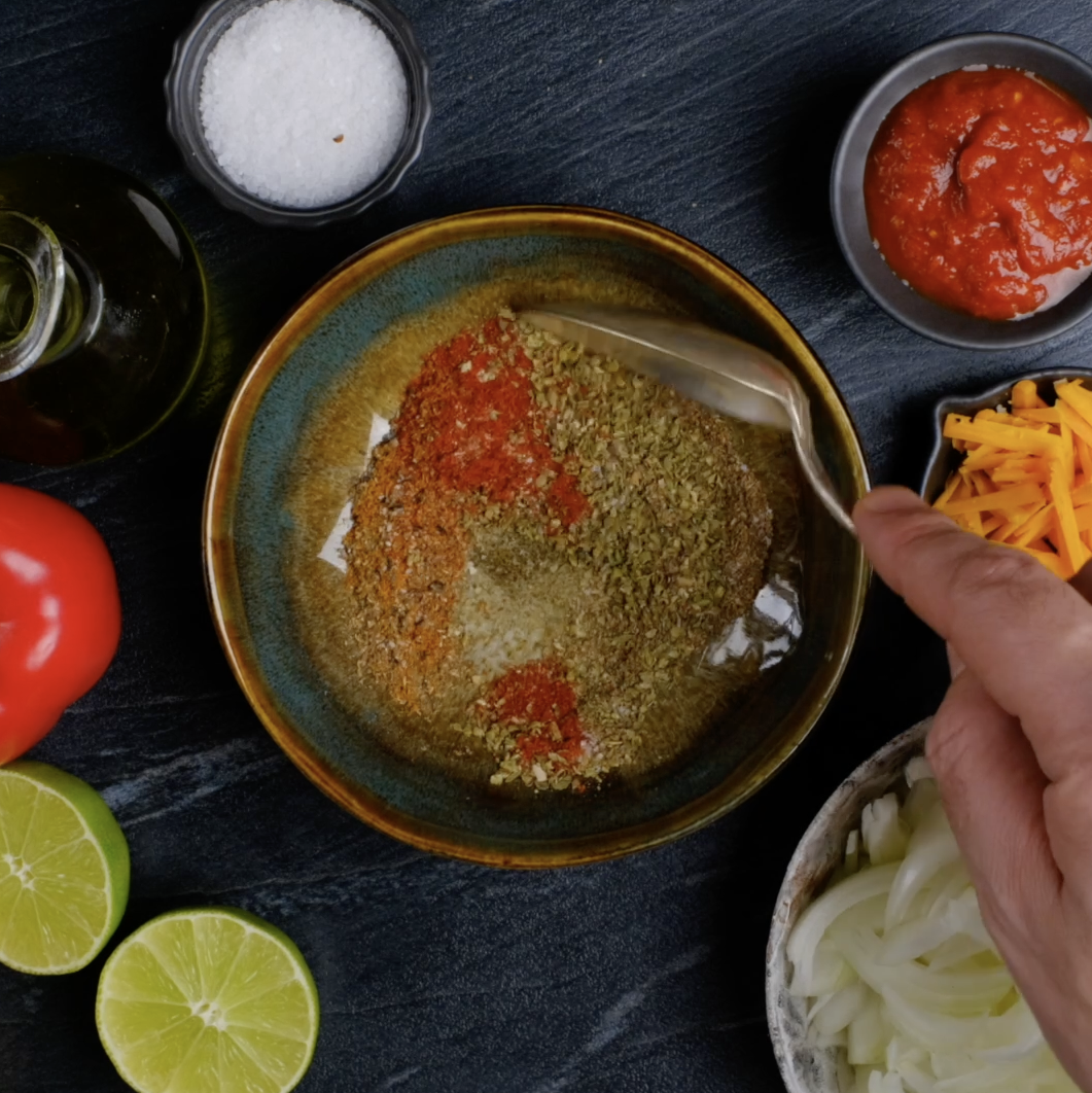 Chicken fajita seasoning being mixed in a bowl.