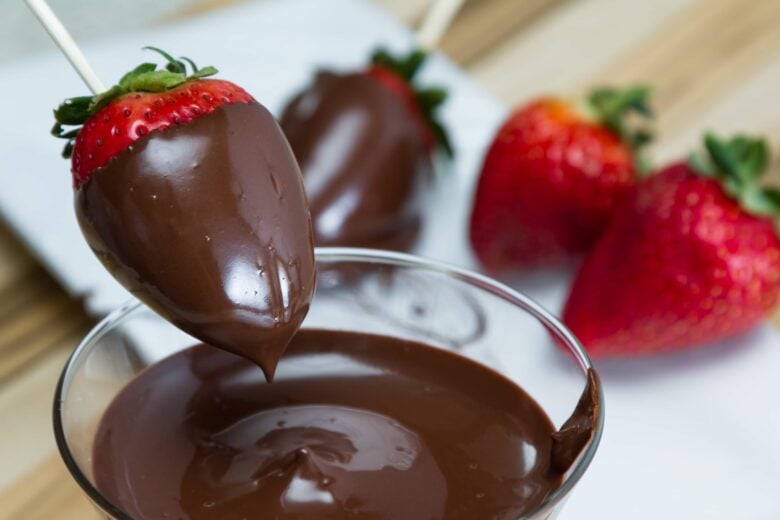 strawberries being dipped in chocolate.