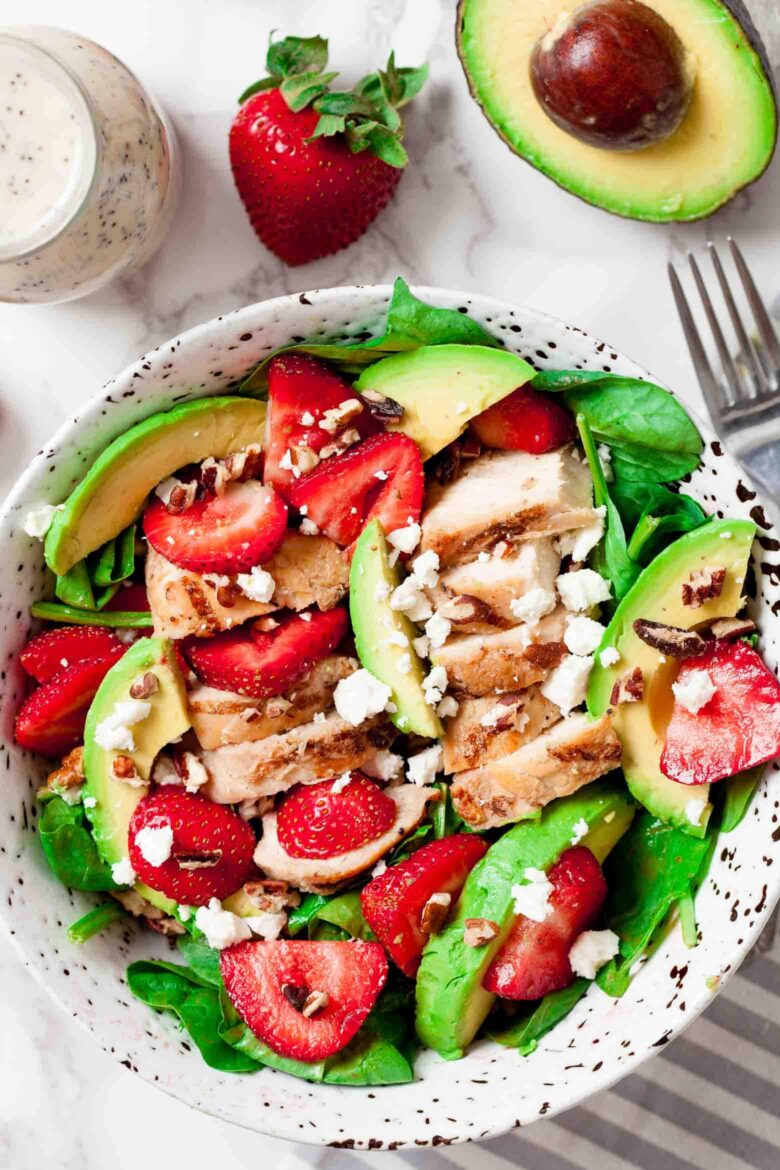 An overhead shot of a bowl of strawberry chicken salad with avocado.