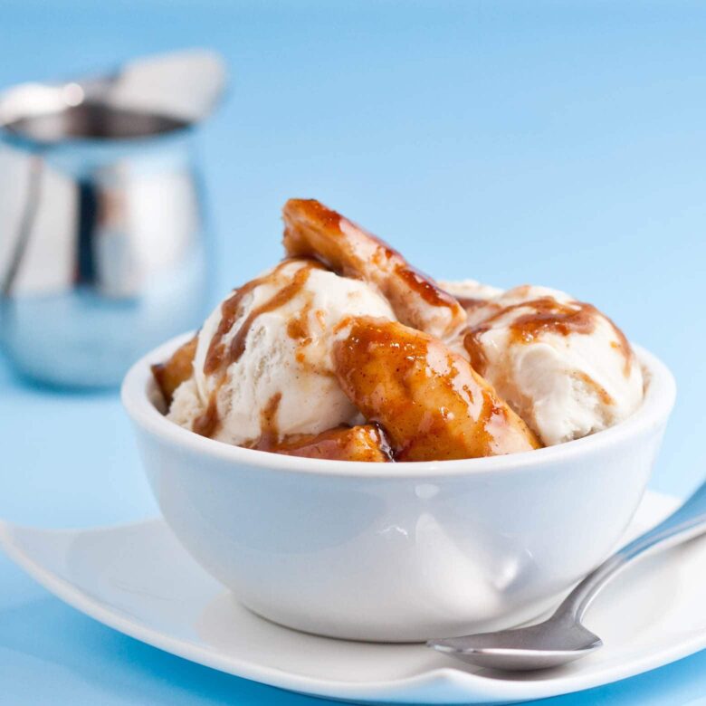 A bowl of Bananas Foster ice cream with a spoon on the side.