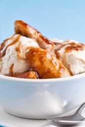 A bowl of Bananas Foster ice cream with a spoon on the side.