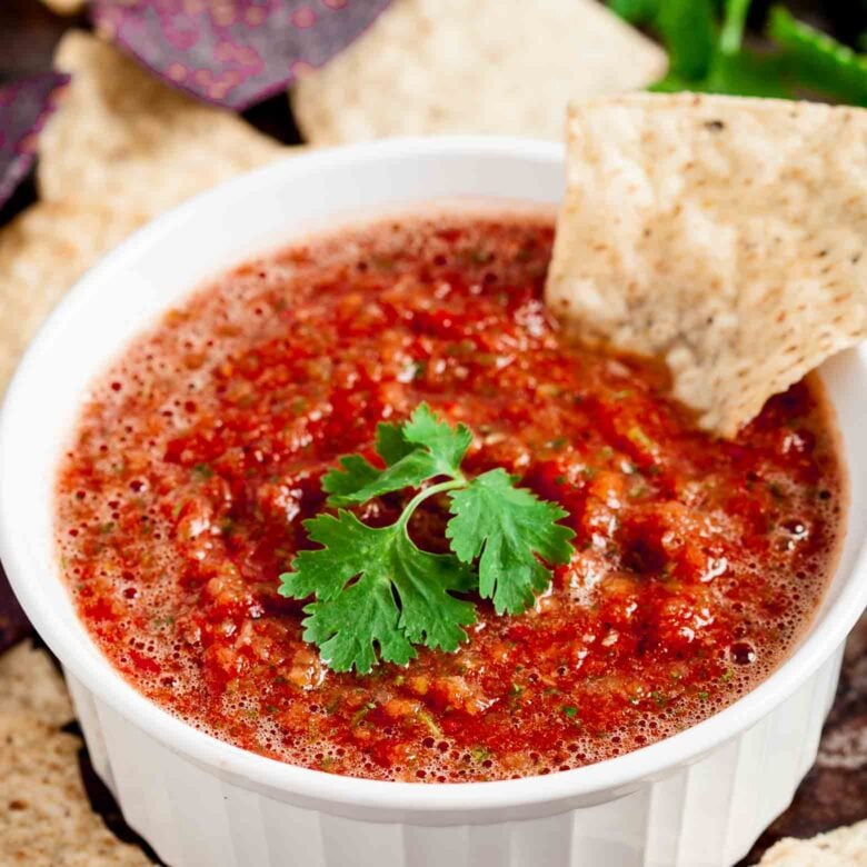 Salsa in a white bowl with tortilla chips.