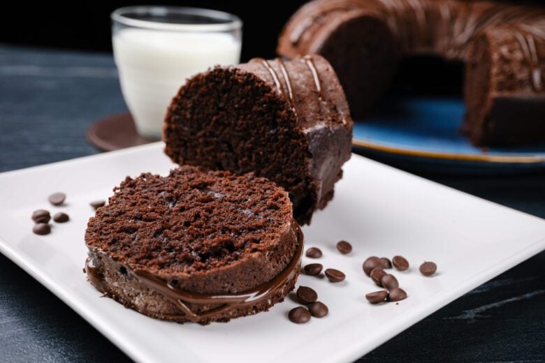 A healthy chocolate bundt cake on a plate with a slice taken out.