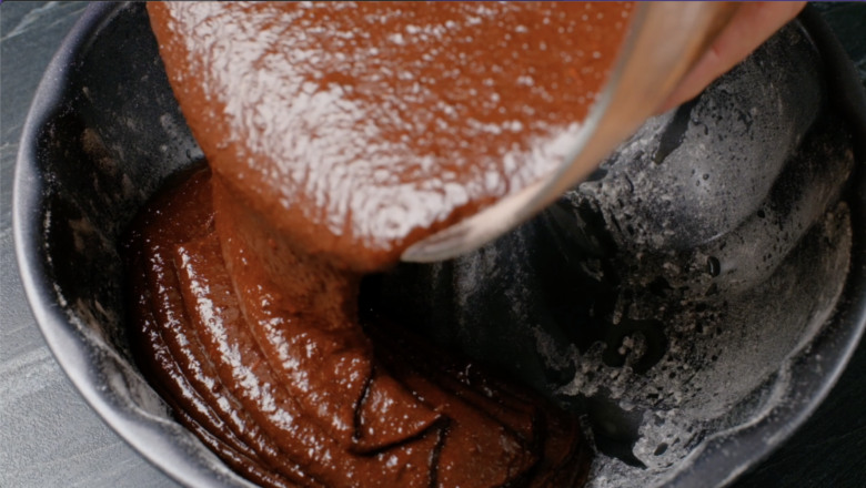 Chocolate cake batter being poured in a pan.
