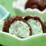 Half-eaten mint chocolate ice cream bon bons on a green saucer.