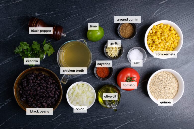 Overhead shot of ingredients to make Mexican quinoa on a dark background.