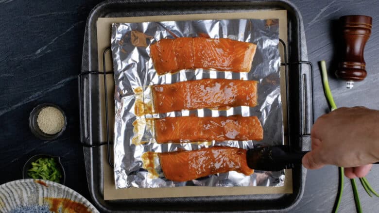 Miso glazed salmon fillet on a wire rack lined with foil and placed over a baking sheet.