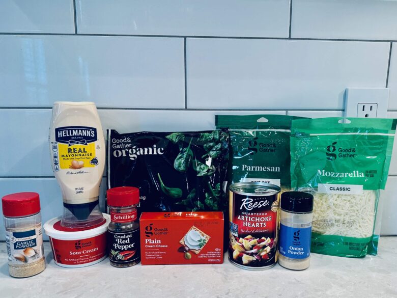 Ingredients to make crockpot spinach artichoke dip on a white ktichen counter.