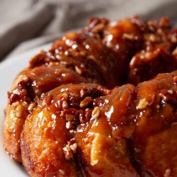 Easy stick buns with caramel-like sauce and pecans on a plate.
