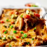 Taco Pasta with tortilla chips and salsa in a casserole dish.