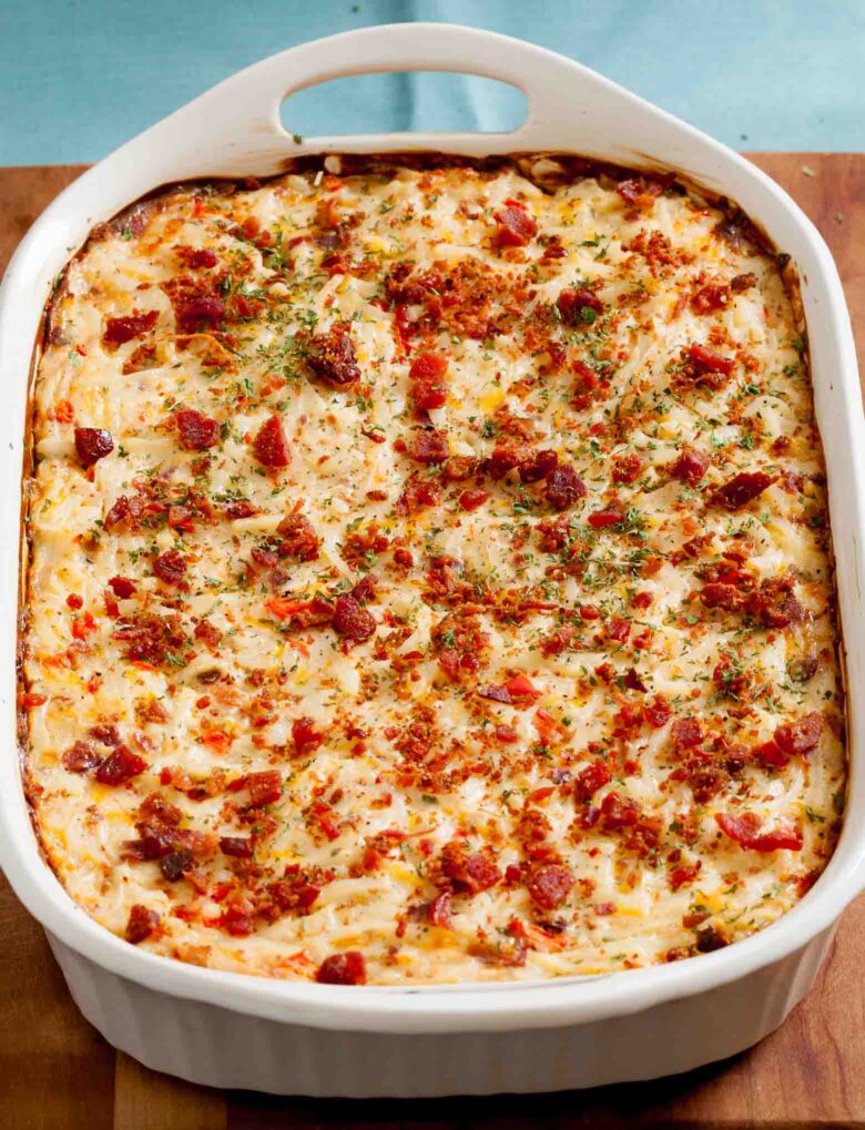 A freshly baked bacon hash brown casserole with melted cheese and bacon pieces on top.