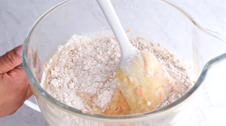 wet ingredients added into dry ingredients for carrot cake cupcakes.