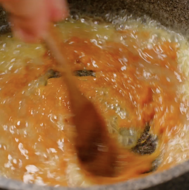 Butter being whisked into melted sugar mixture.