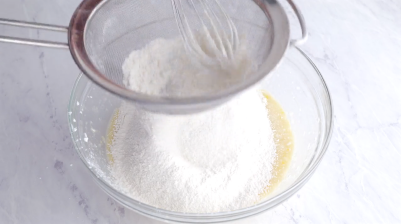 Sifting flour into crepe mixture to make easy sweet crepes.
