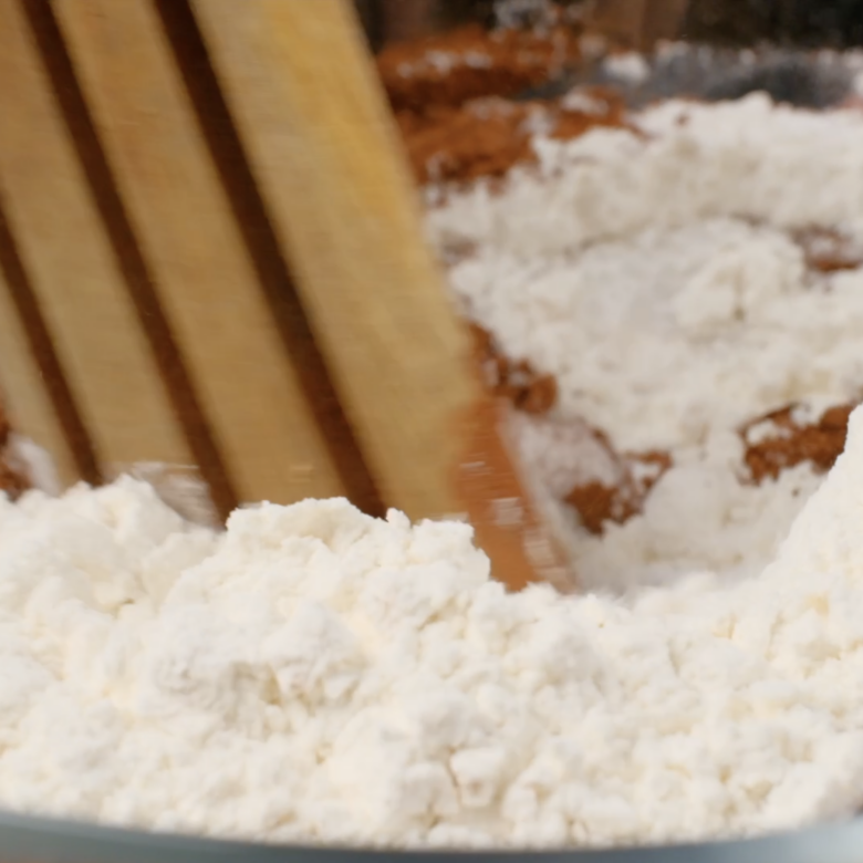 Dry ingredients to make eggless chocolate cake being mixed/